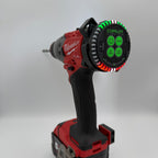 A Milwaukee cordless drill with a red and black body, featuring a circular LED alignment monitor on the back of the drill with green and white markings, shown against a neutral gray background.